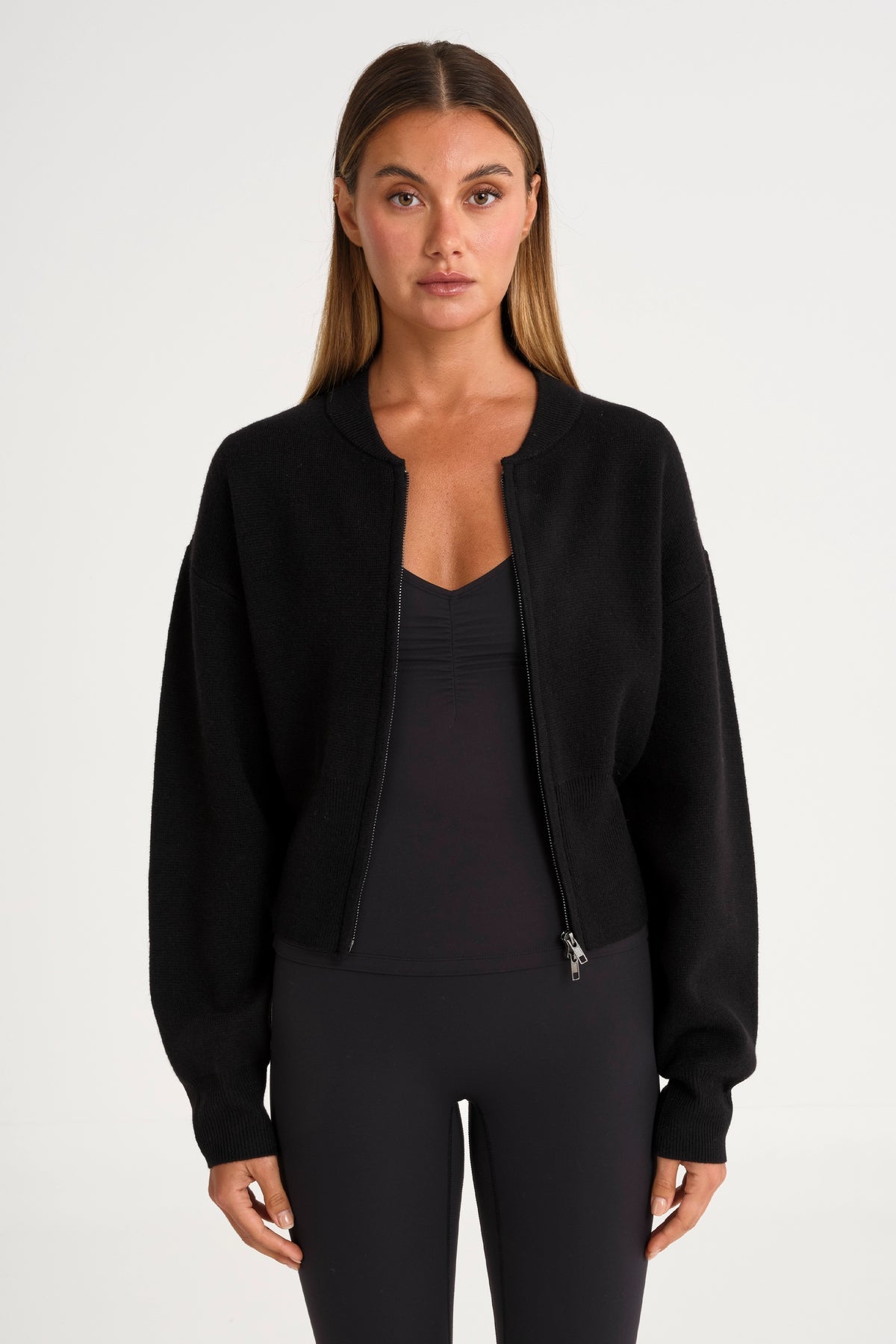 Woman wearing a black jacket over a black top and pants