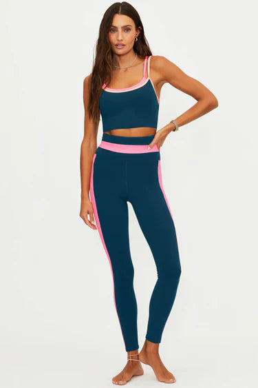 Woman wearing a blue athletic outfit with pink accents 