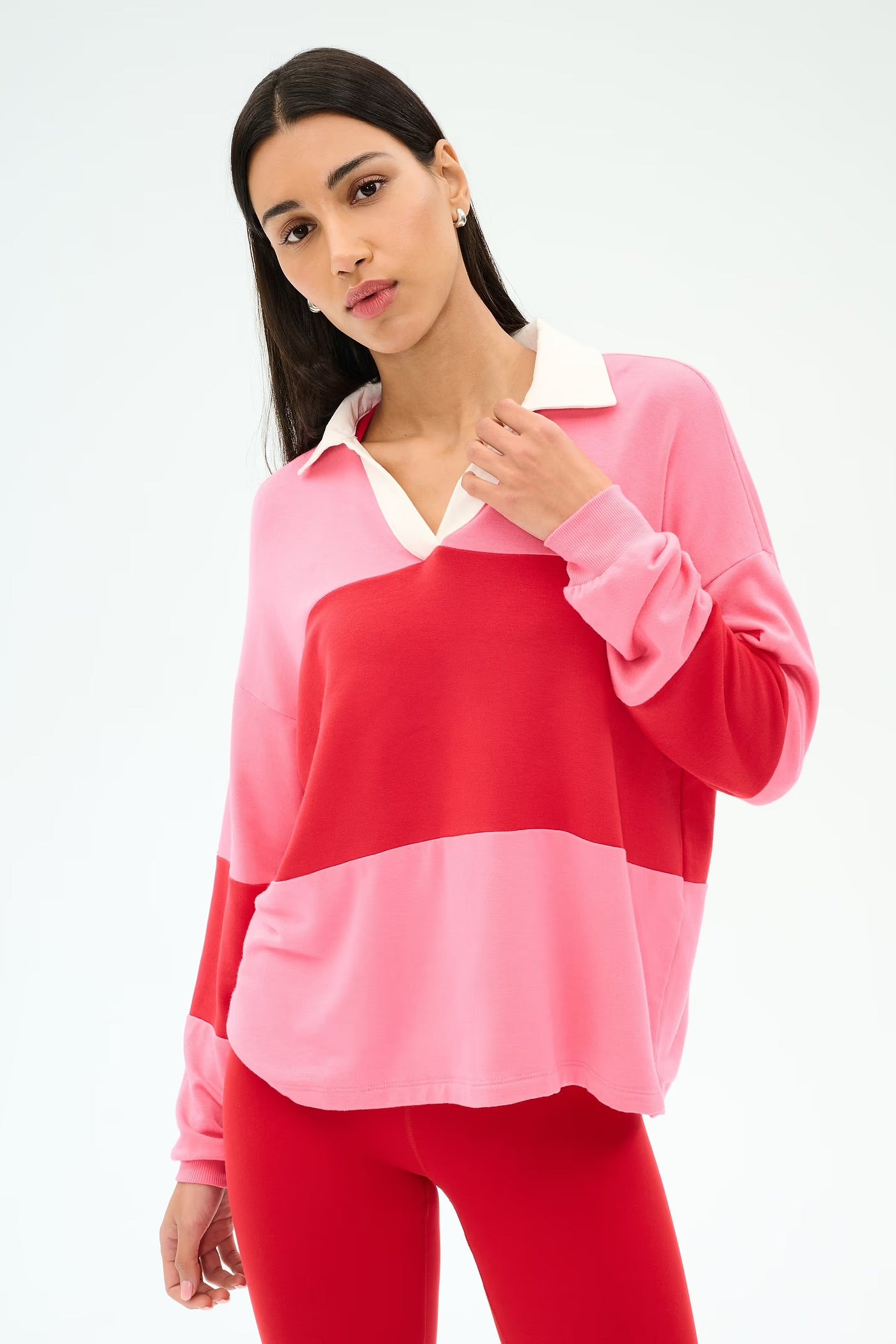 Woman wearing a pink and red color-blocked outfit with collar.