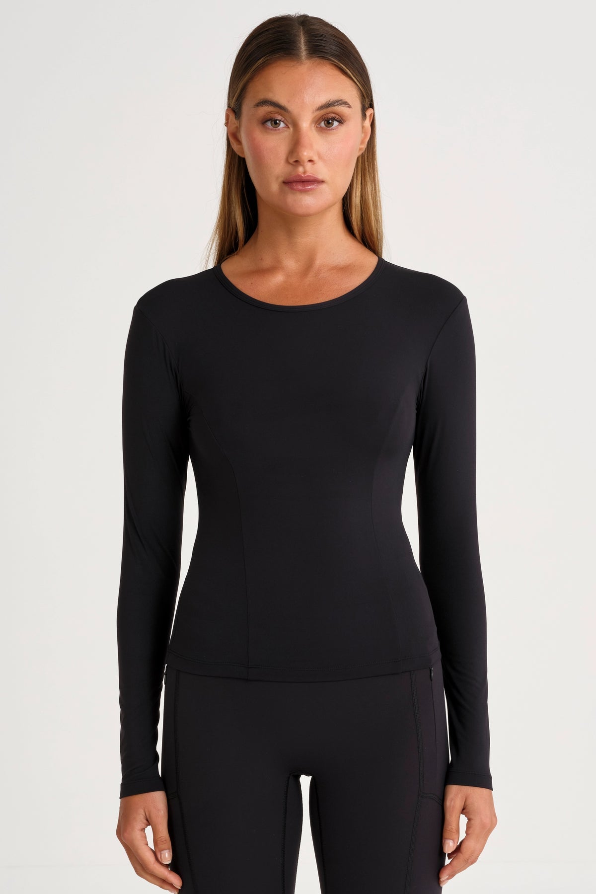 Woman wearing a black long-sleeve top and black leggings