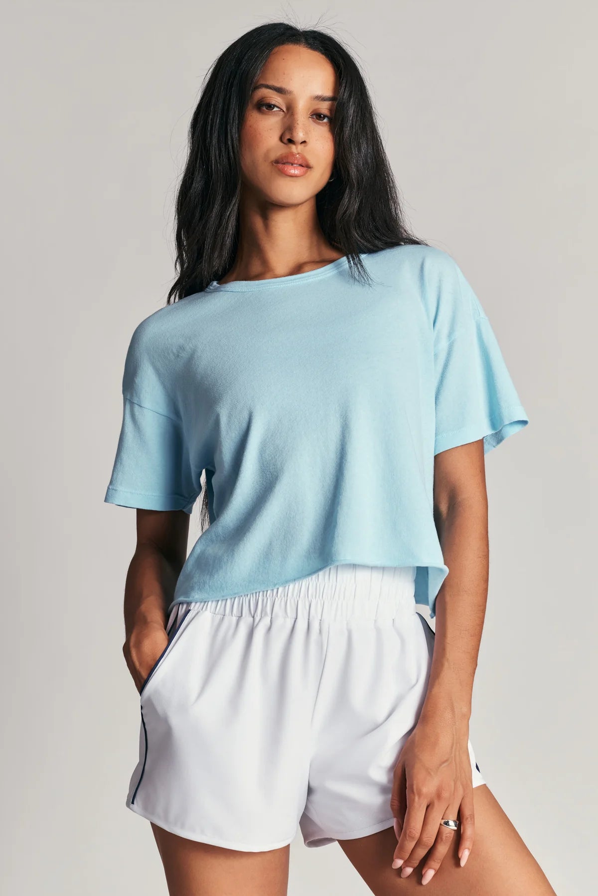 Woman wearing a light blue top and white shorts 