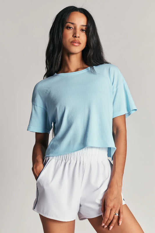 Woman wearing a light blue top and white shorts 