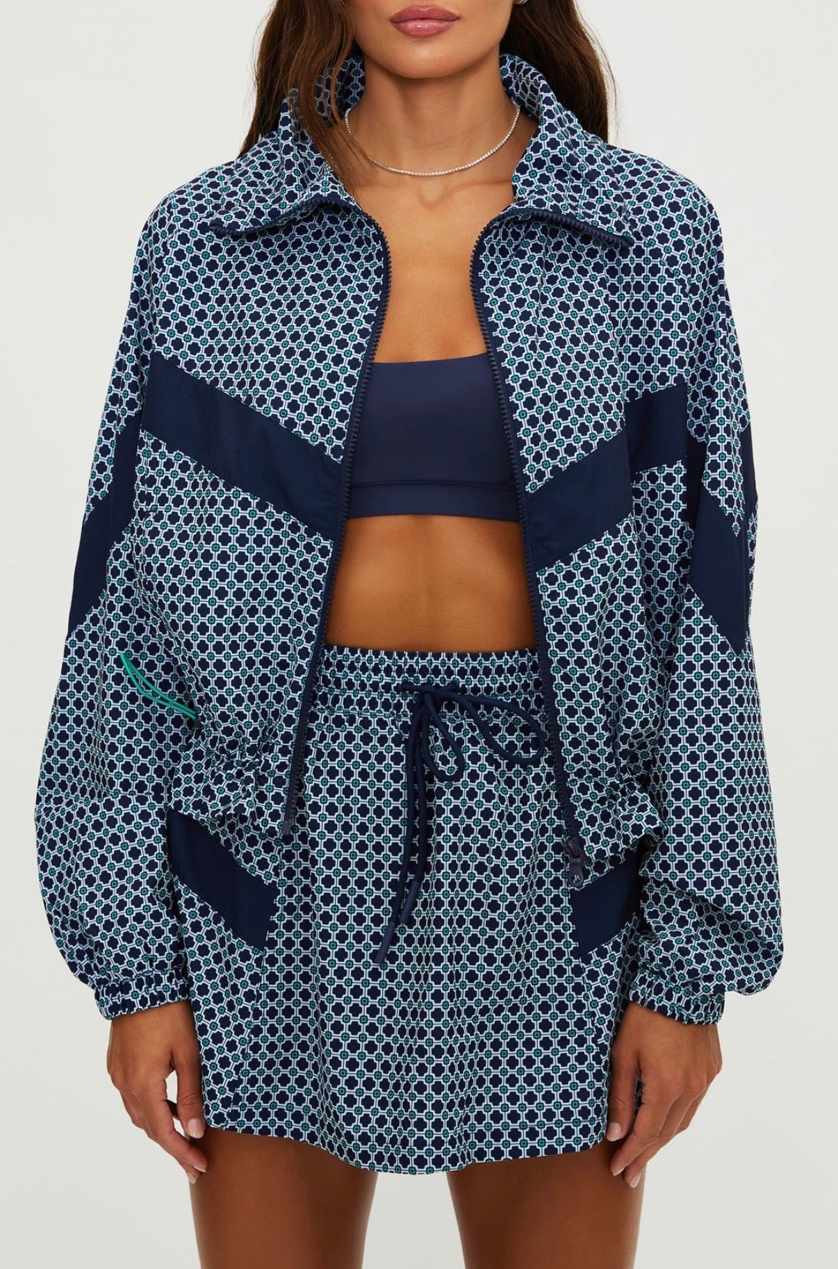Person wearing a blue and white patterned outfit with a matching jacket and shorts 