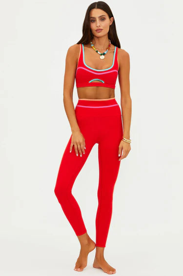 Woman wearing a red sports bra and leggings 