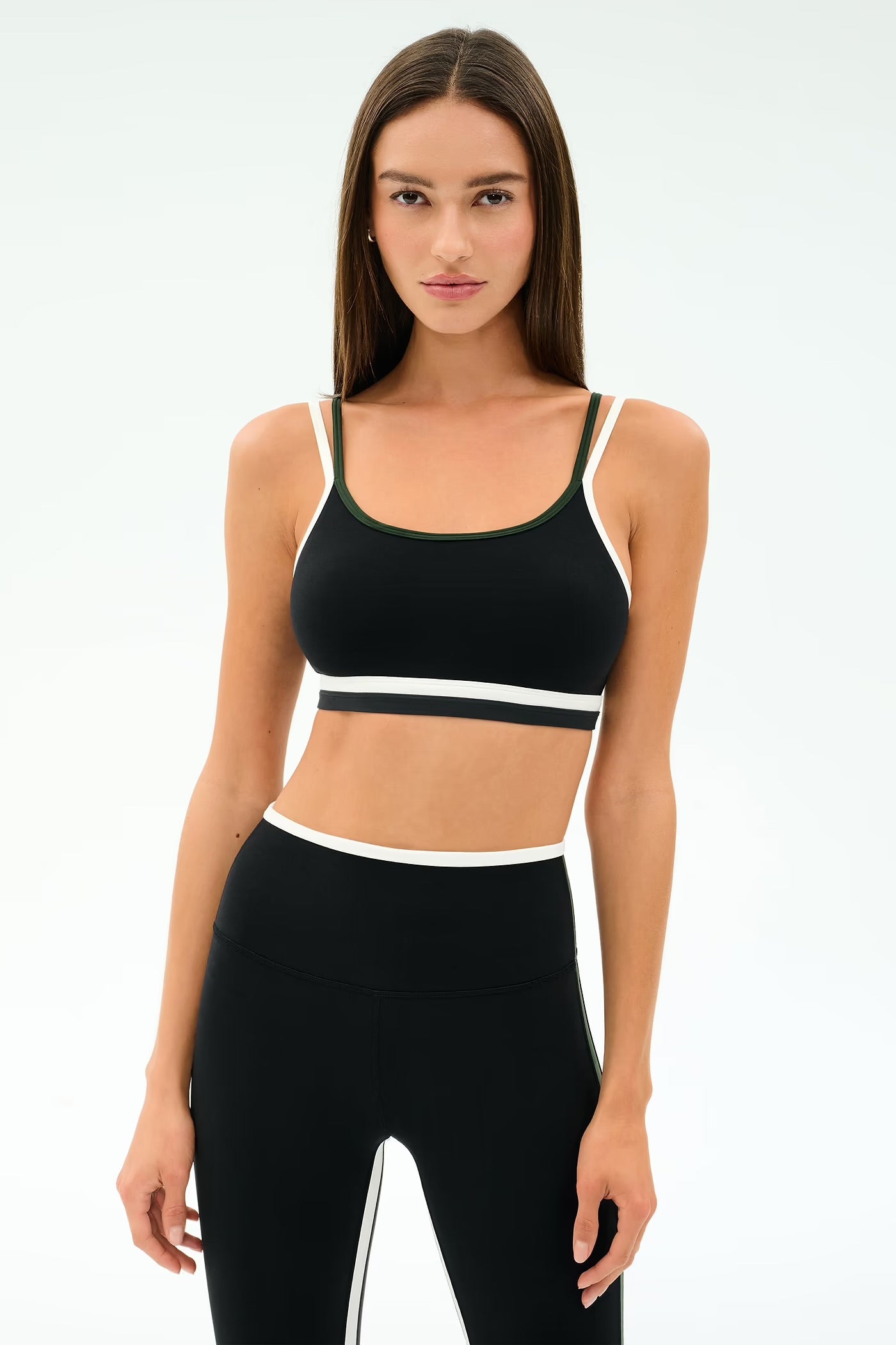 Woman wearing a black sports bra and leggings with a white stripe 