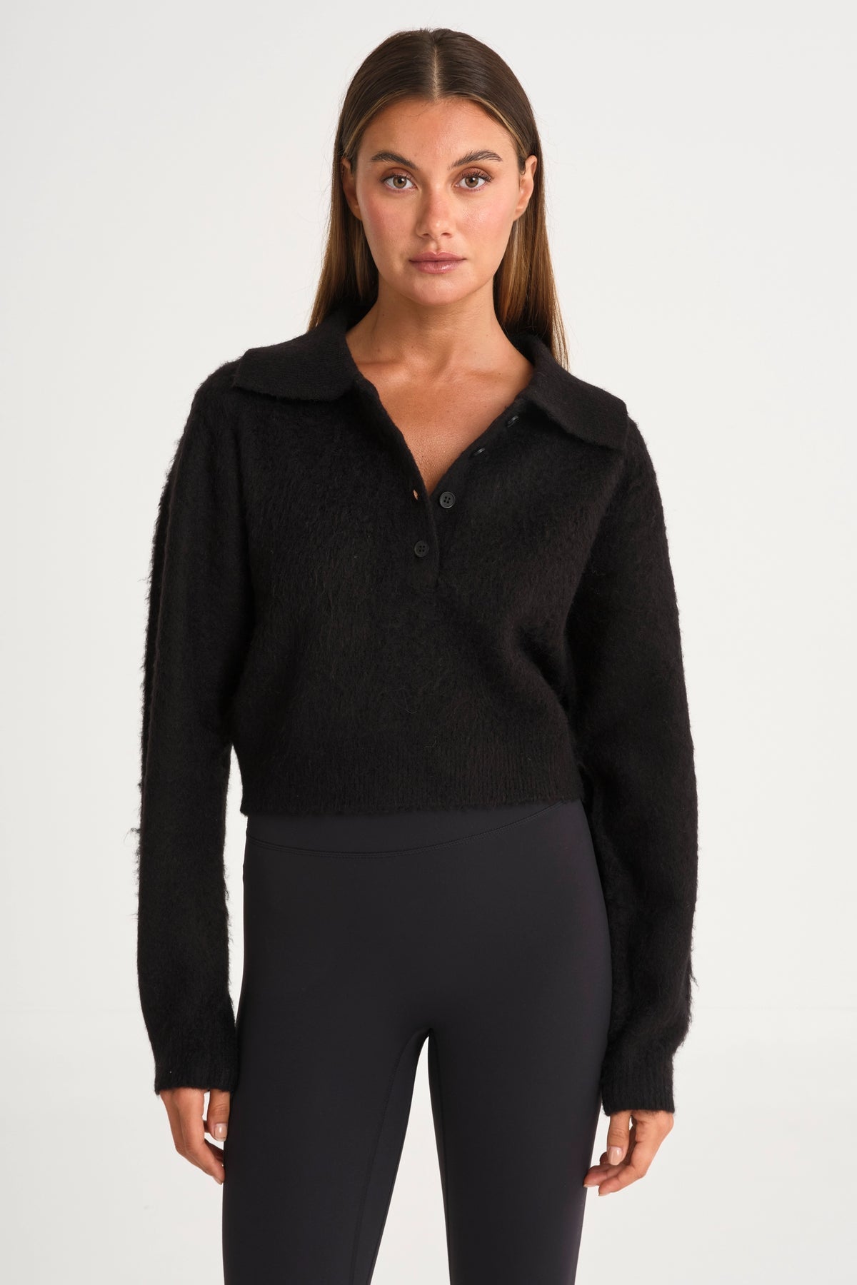 Woman wearing a black long-sleeve shirt with a collar 