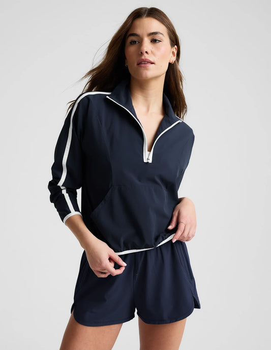 Woman wearing a navy blue tracksuit with white accents 