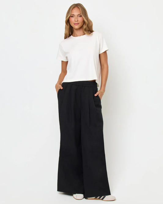 Woman wearing a white top and black wide-leg pants