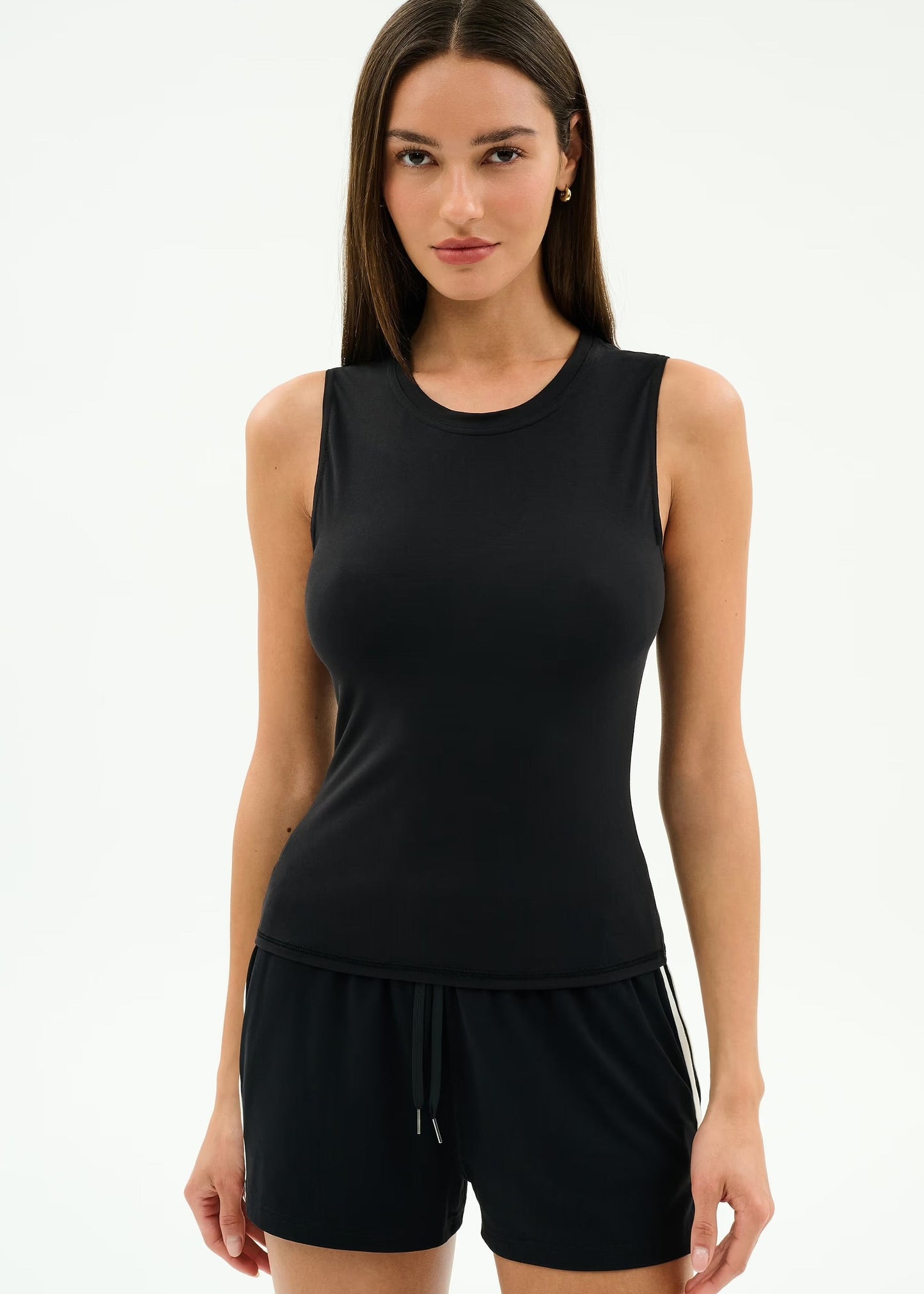 Woman wearing a black sleeveless top and shorts
