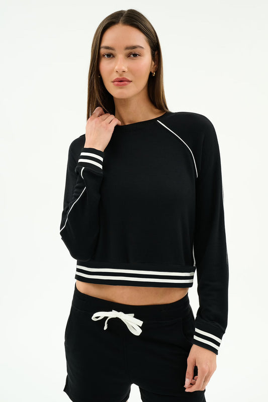 Woman wearing a black long-sleeve crop top with white stripes