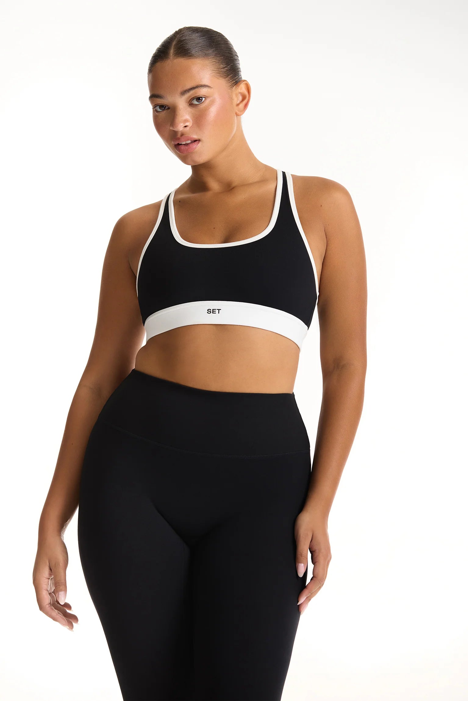 Woman wearing a black sports bra with white accents