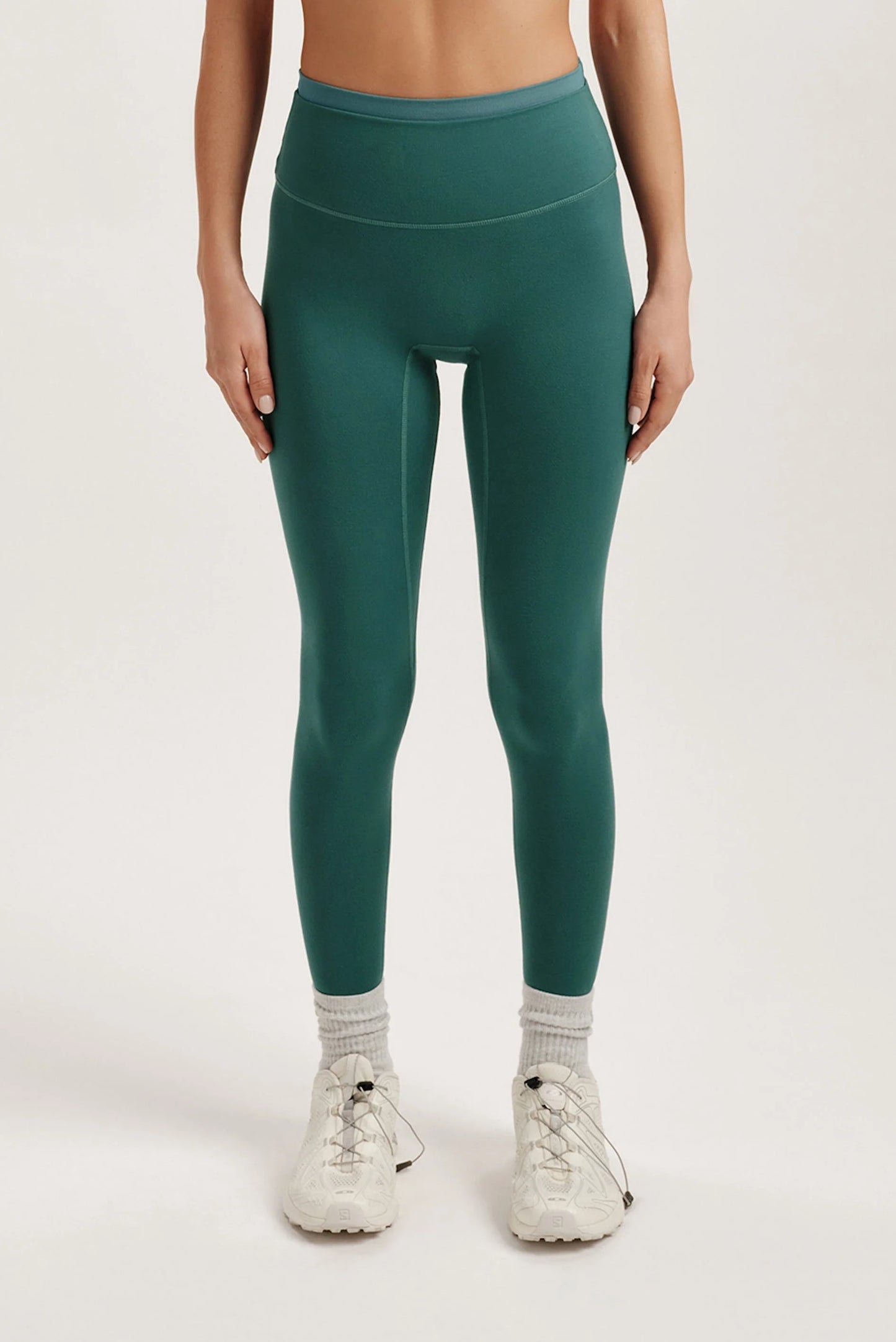Teal leggings worn by a person on a white background