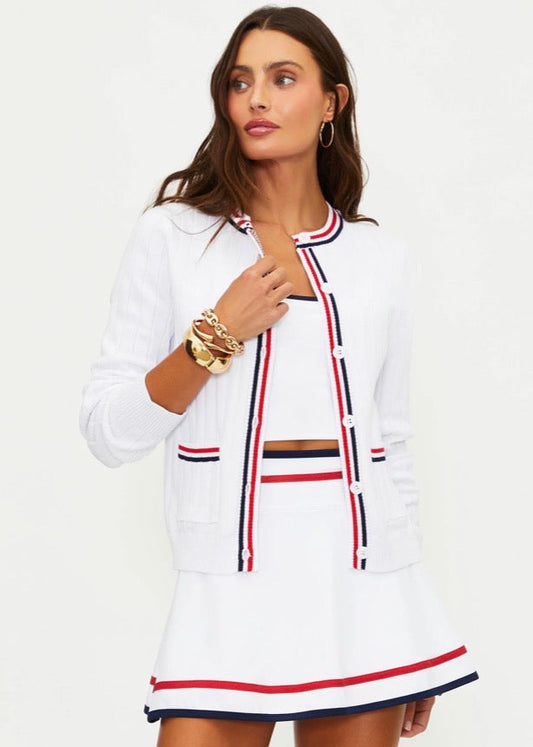 Woman wearing a white outfit with red and blue accents on a white background