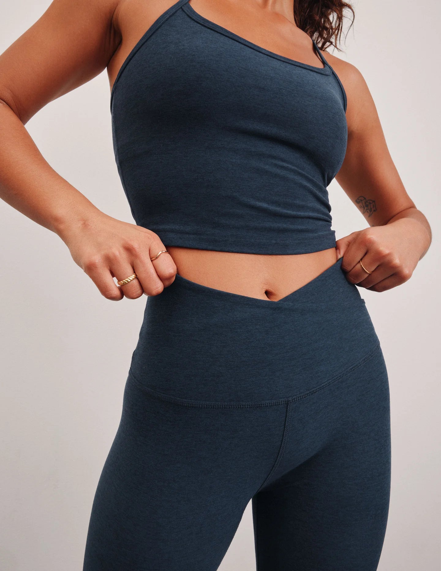 Person wearing a dark blue athletic outfit on a plain background